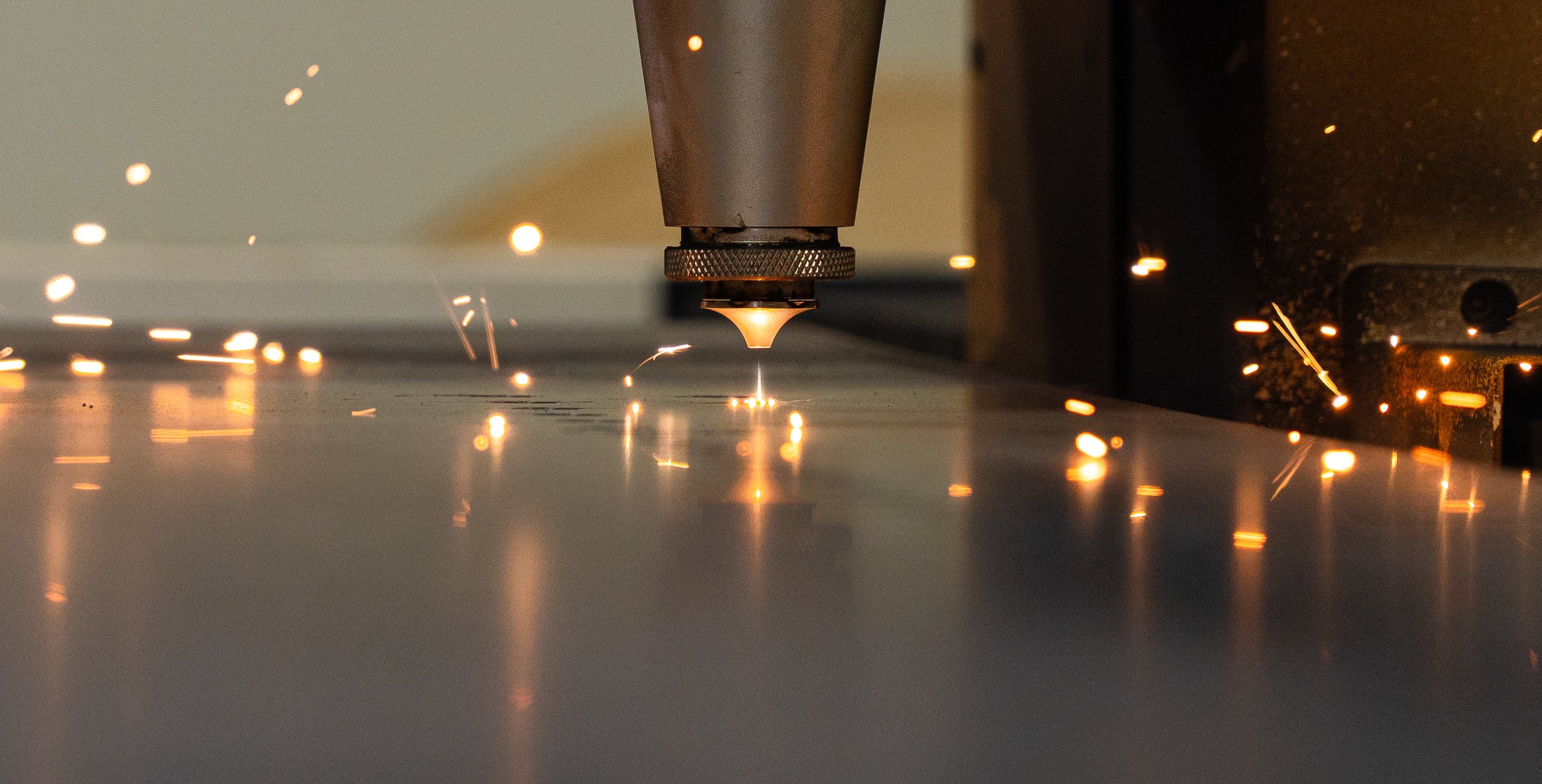 Laser cutting machine in action with sparks on a dark background